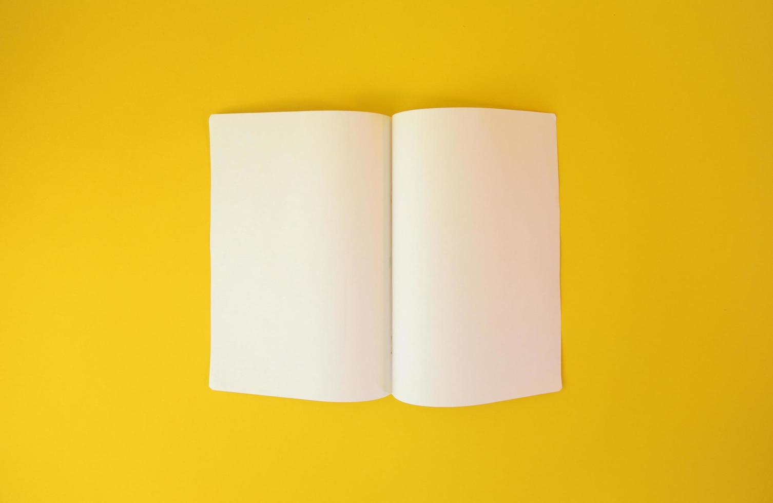 Opened two pages of a notebook on yellow background. Copy space paper for photo or text message.