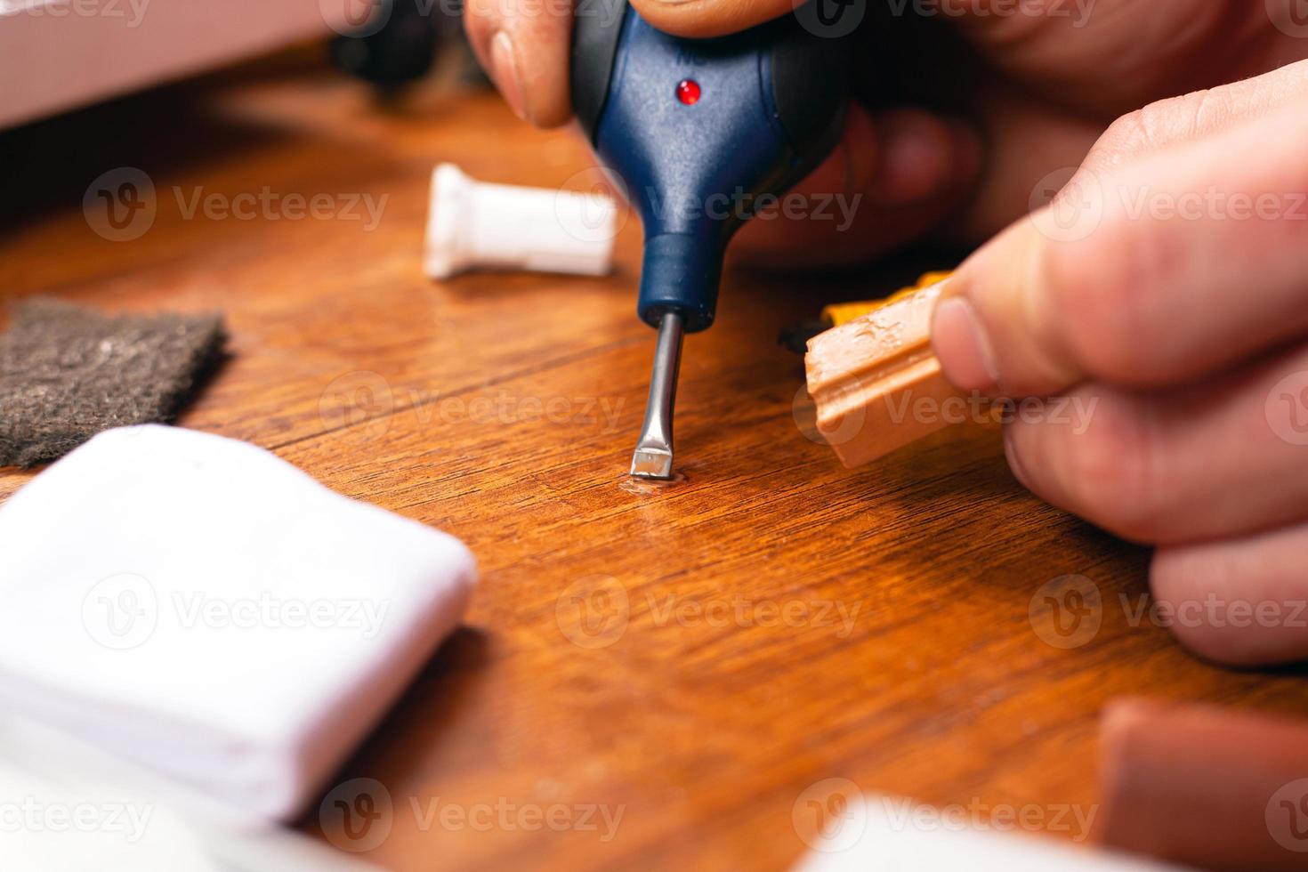 The master closes the scratch of laminate parquet and wooden furniture photo