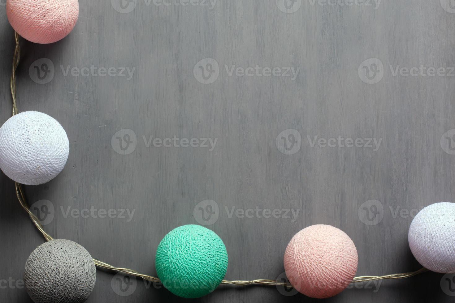 Garland with colorful cotton balls of pastel colors on a gray background photo