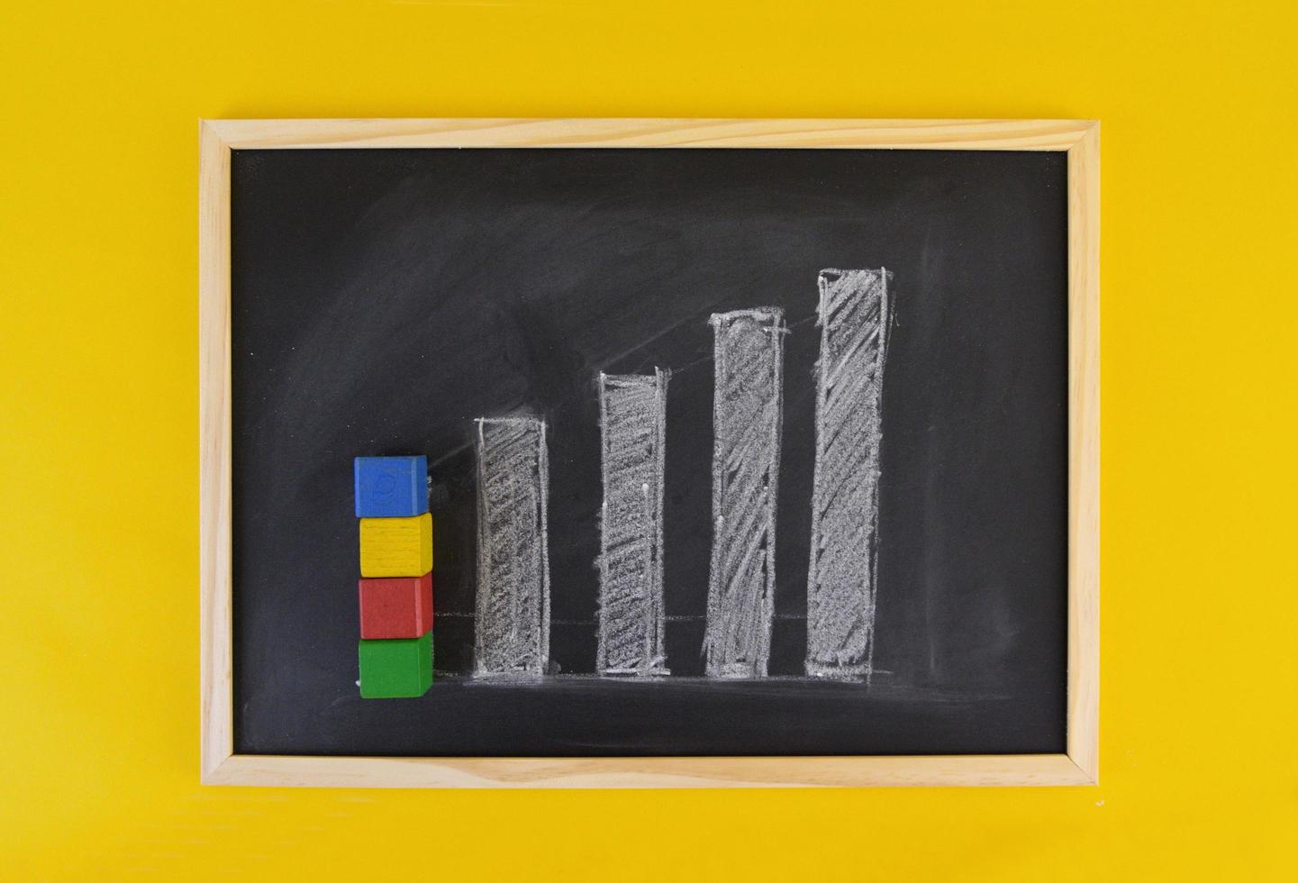 Hand-drawn progress growing chart on black chalkboard among yellow vivid background. Business concept picture frame. photo
