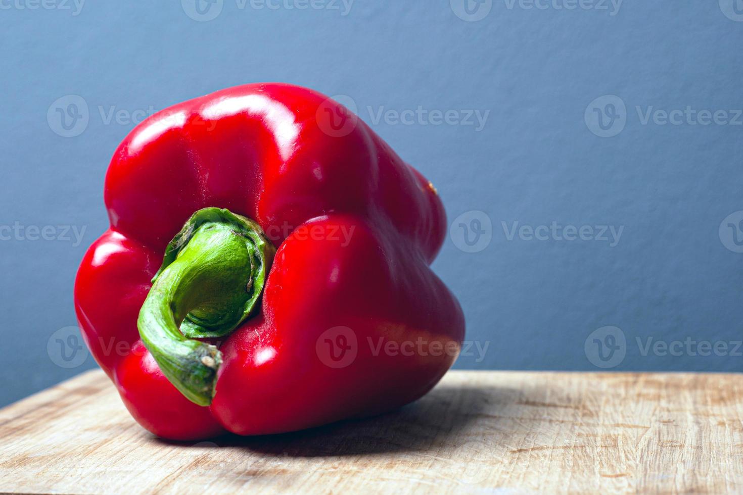 Sweet red big paprika pepper on a gray background with copy space photo