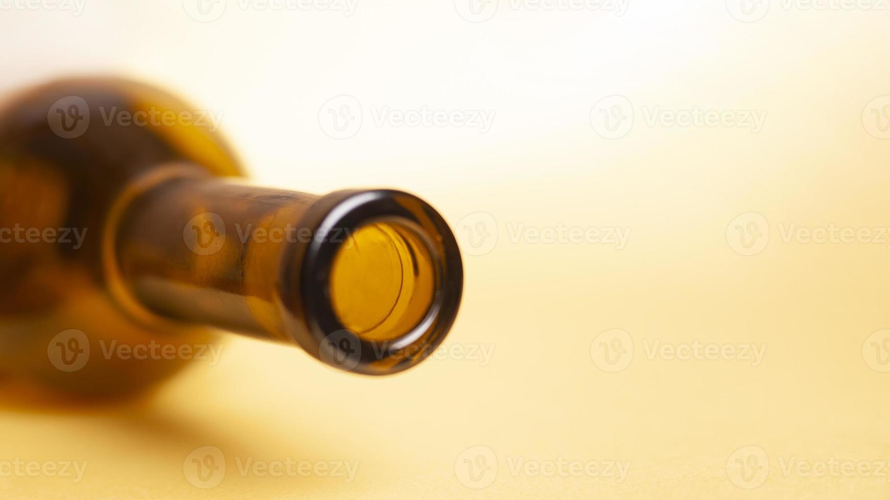 Botella de vino vacía sobre un fondo amarillo foto