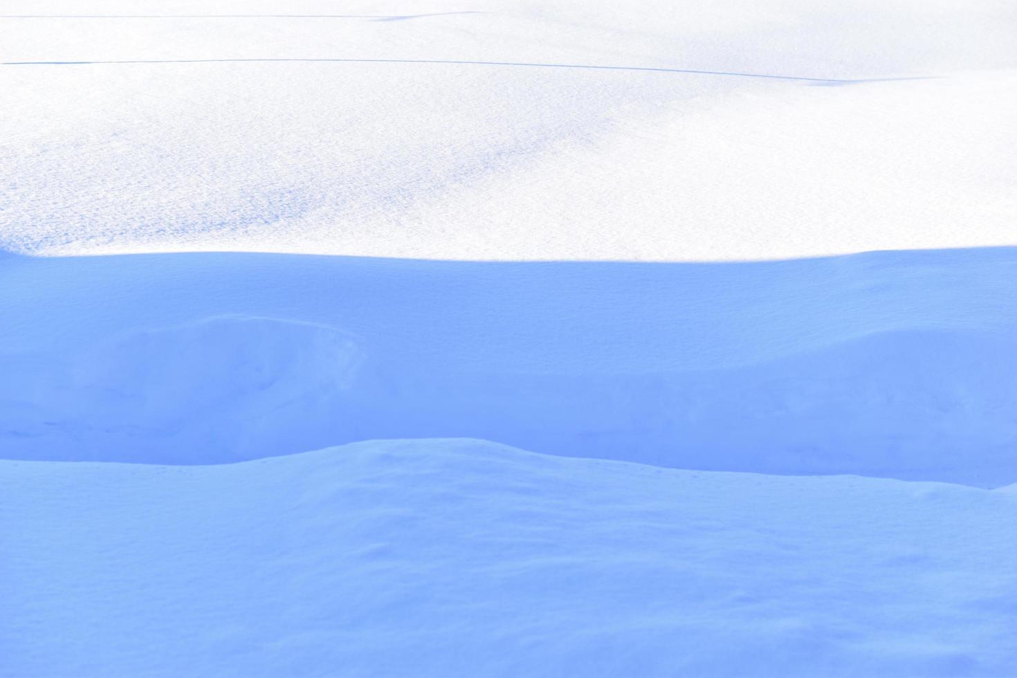 Snowy surface in winter with shadows in the evening photo