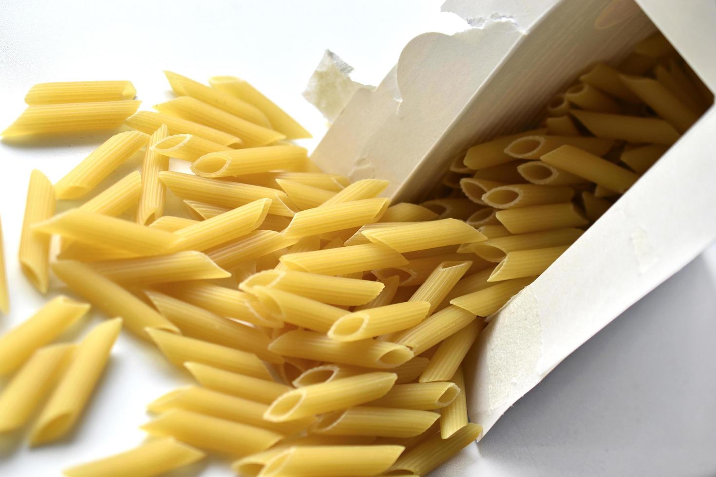 Yellow macaroni from a paper box on a white background photo