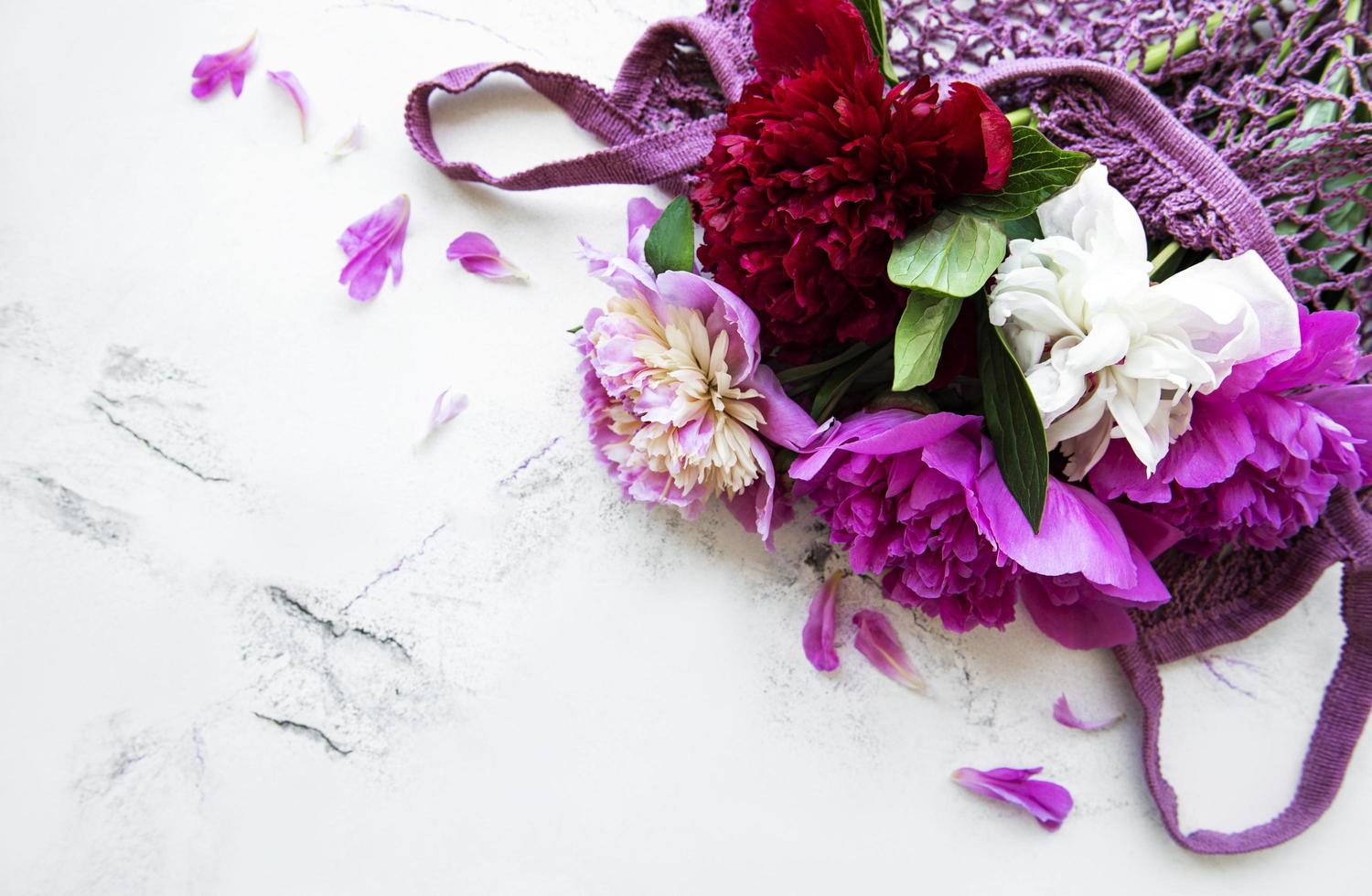 Pink peony flowers in string bag photo