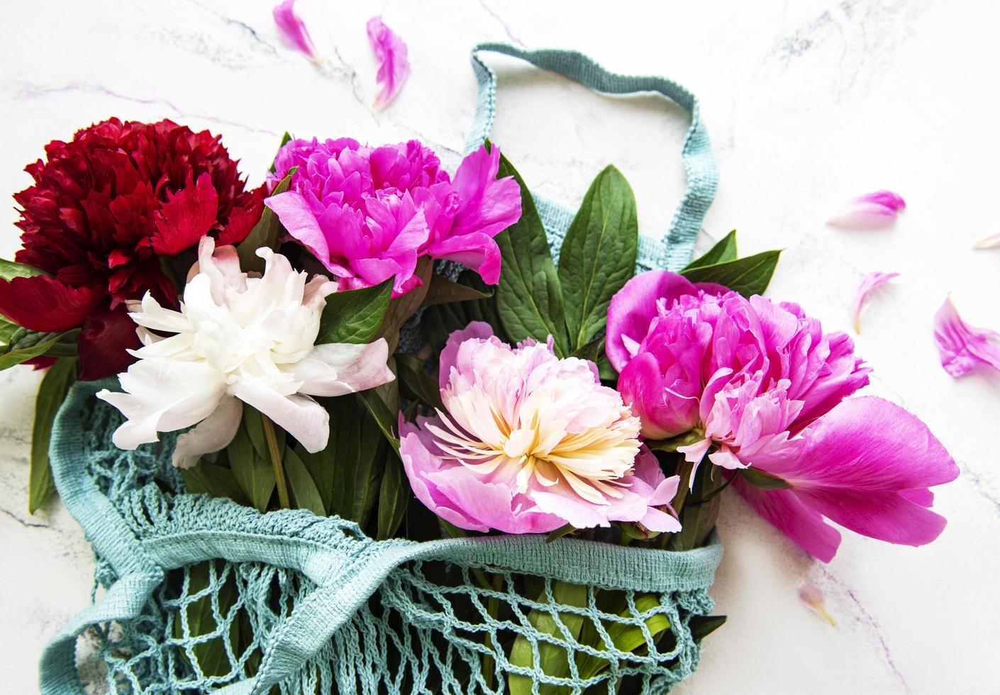 Pink peony flowers in string bag photo