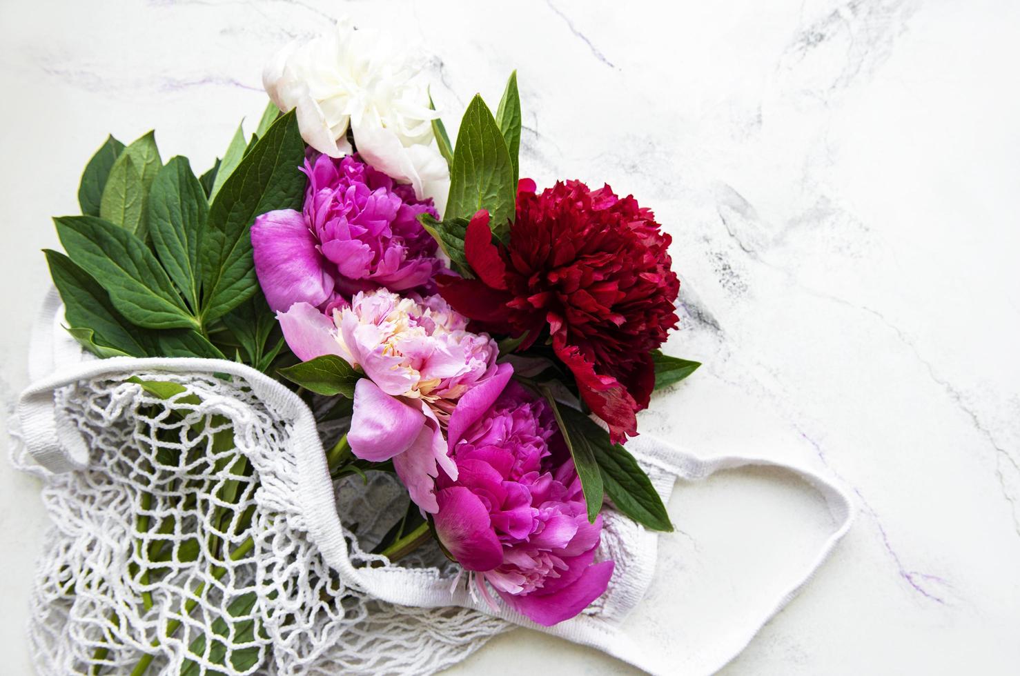 flores de peonía rosa en bolsa de hilo foto