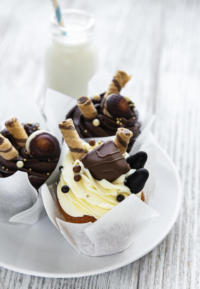 cupcakes de chocolate en un plato y una botella de leche foto