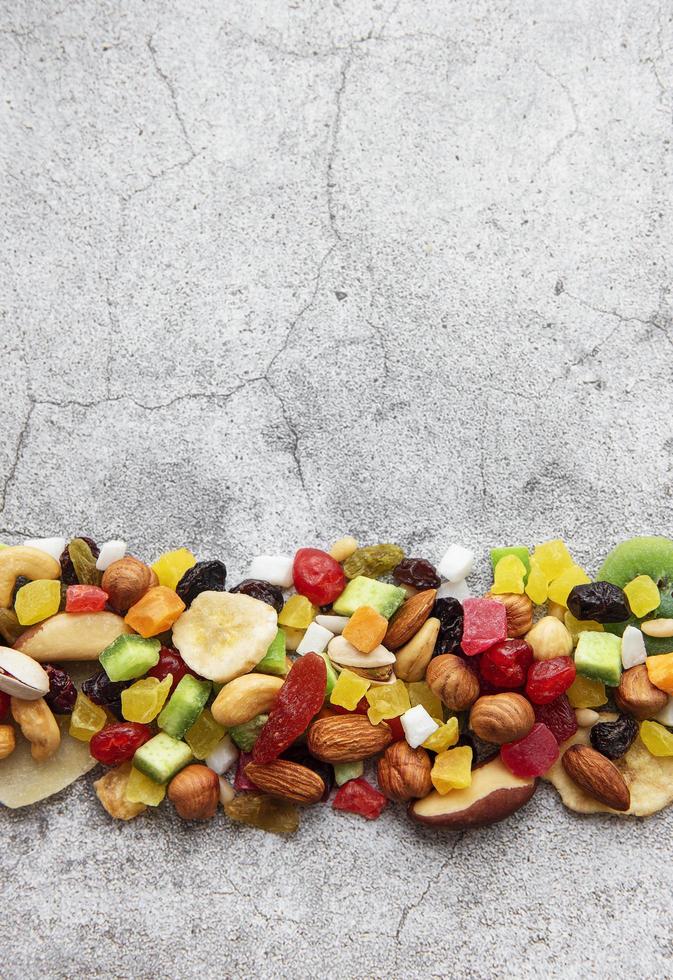 Various dried fruits and nuts on a gray concrete background photo