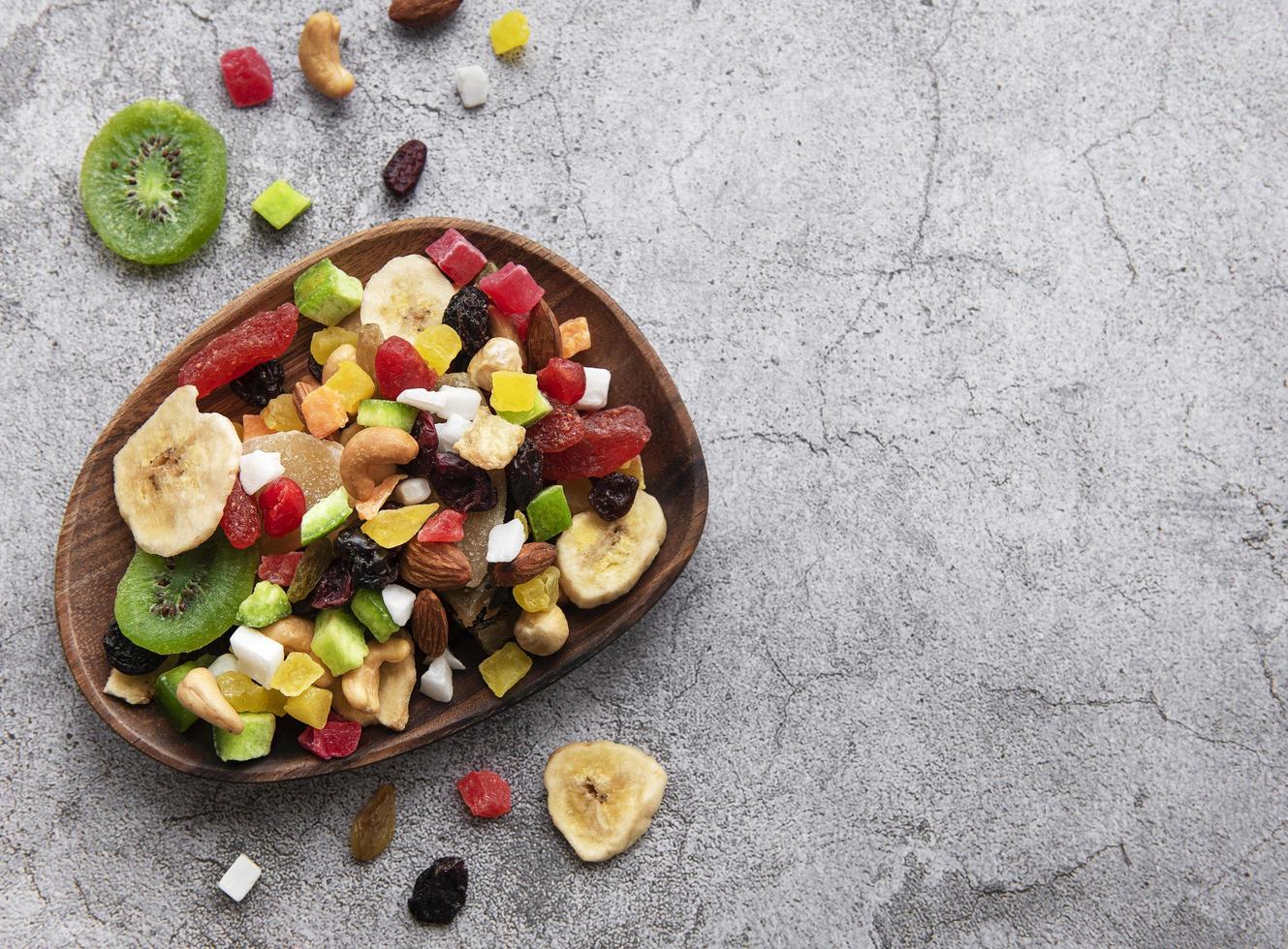 Recipiente con diversos frutos secos y nueces sobre un fondo de hormigón gris foto