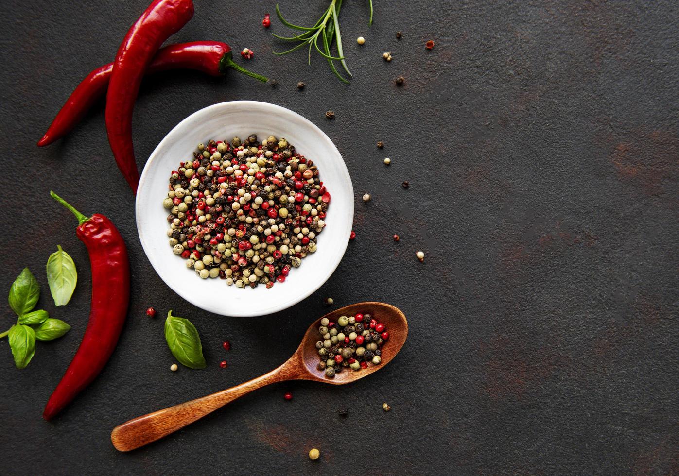 Red hot chili pepper corns and pods on dark background, top view photo