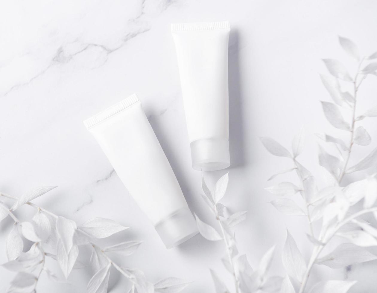 White tubes of cream on a marble background photo
