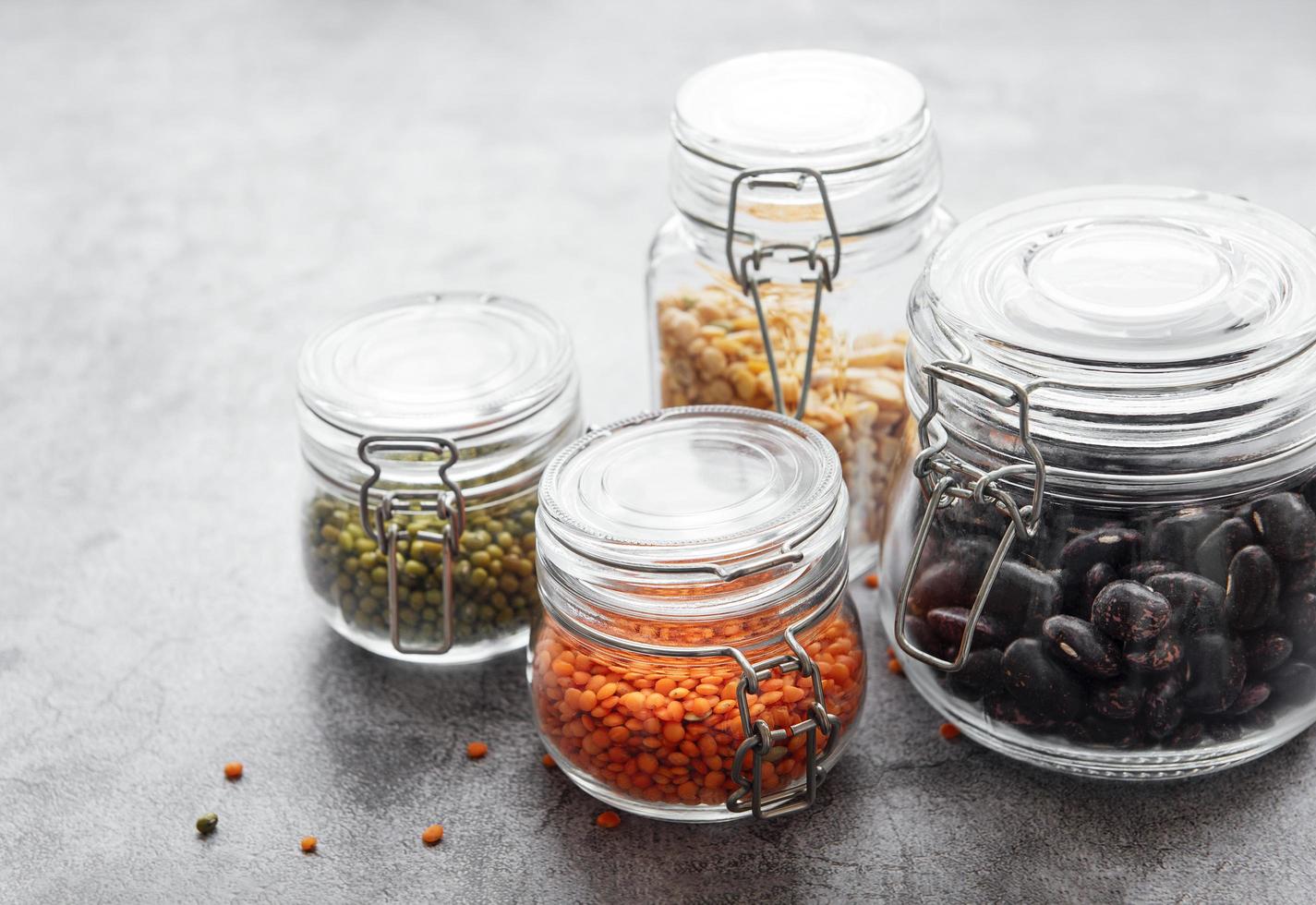 Glass jars with different types of legumes photo