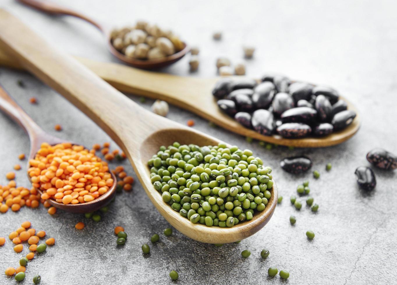 Spoons with different types of legumes photo