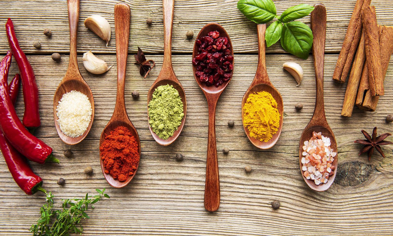 Various colorful herbs and spices on wooden table photo