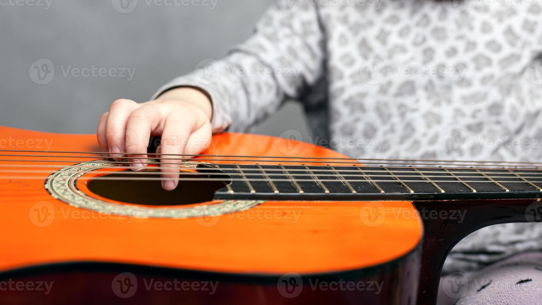 Little girl and acoustic guitar photo