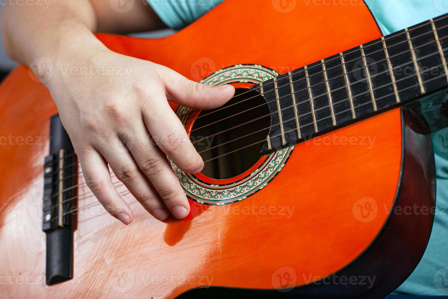 chico tocando una guitarra acústica de seis cuerdas foto