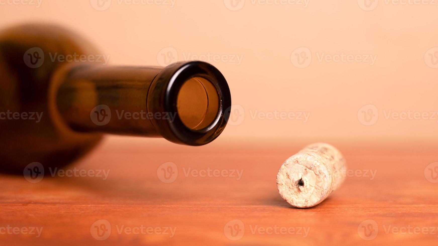 Wine cork and lying empty bottle on the table photo