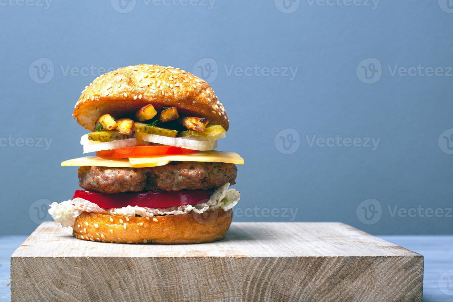 Gran hamburguesa jugosa con espacio de copia sobre fondo gris foto