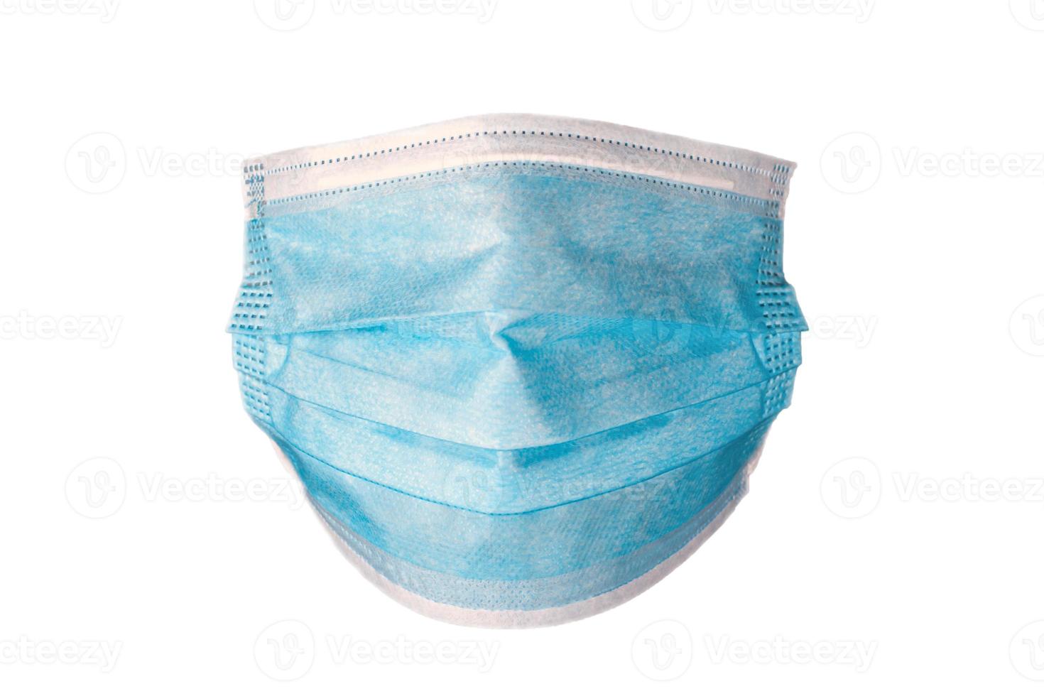 Máscara azul quirúrgica desechable protectora médica aislado sobre fondo blanco. foto