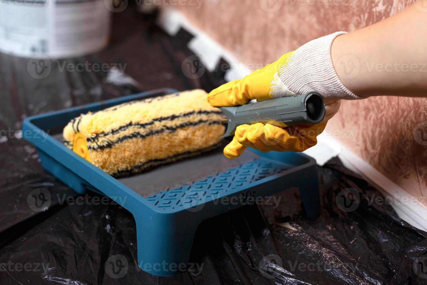 Roller in a tray with gray paint photo