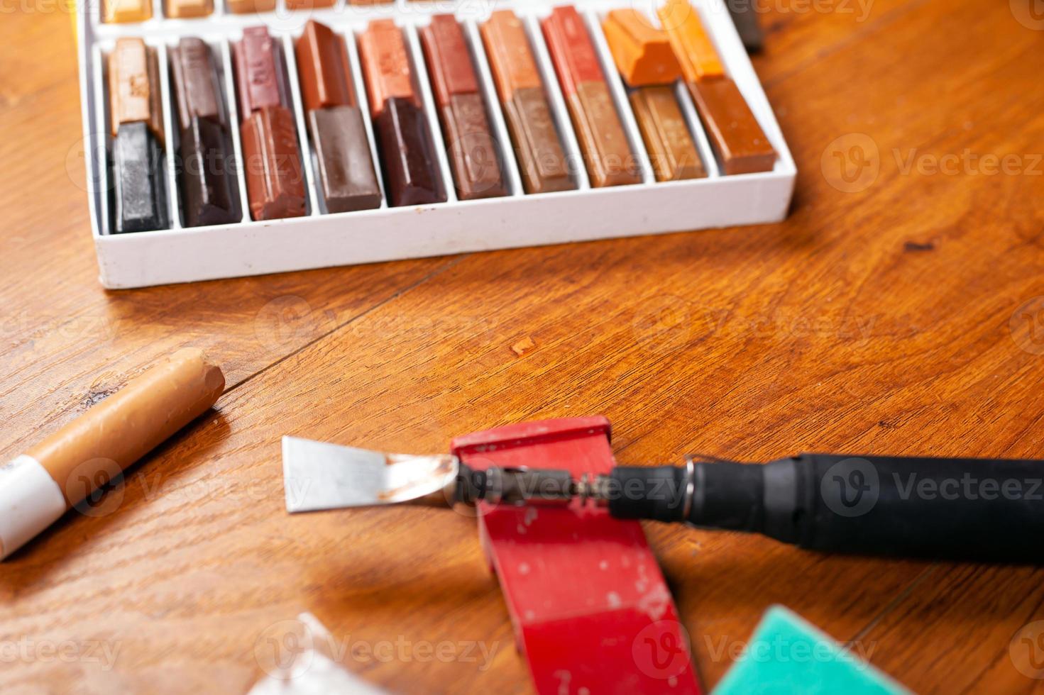 Tools and a set of wax pencils for sealing scratches and chips photo