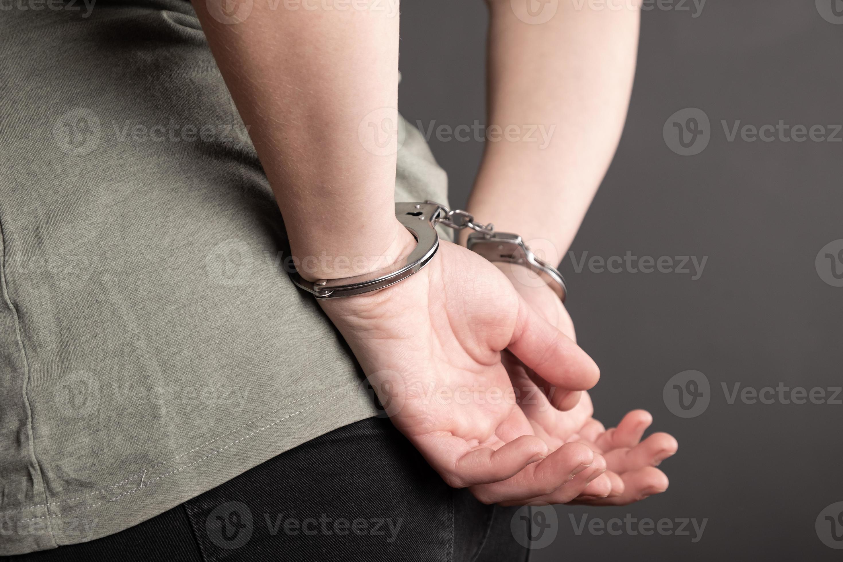Arrested human with handcuffed hands closeup, law and justice concept