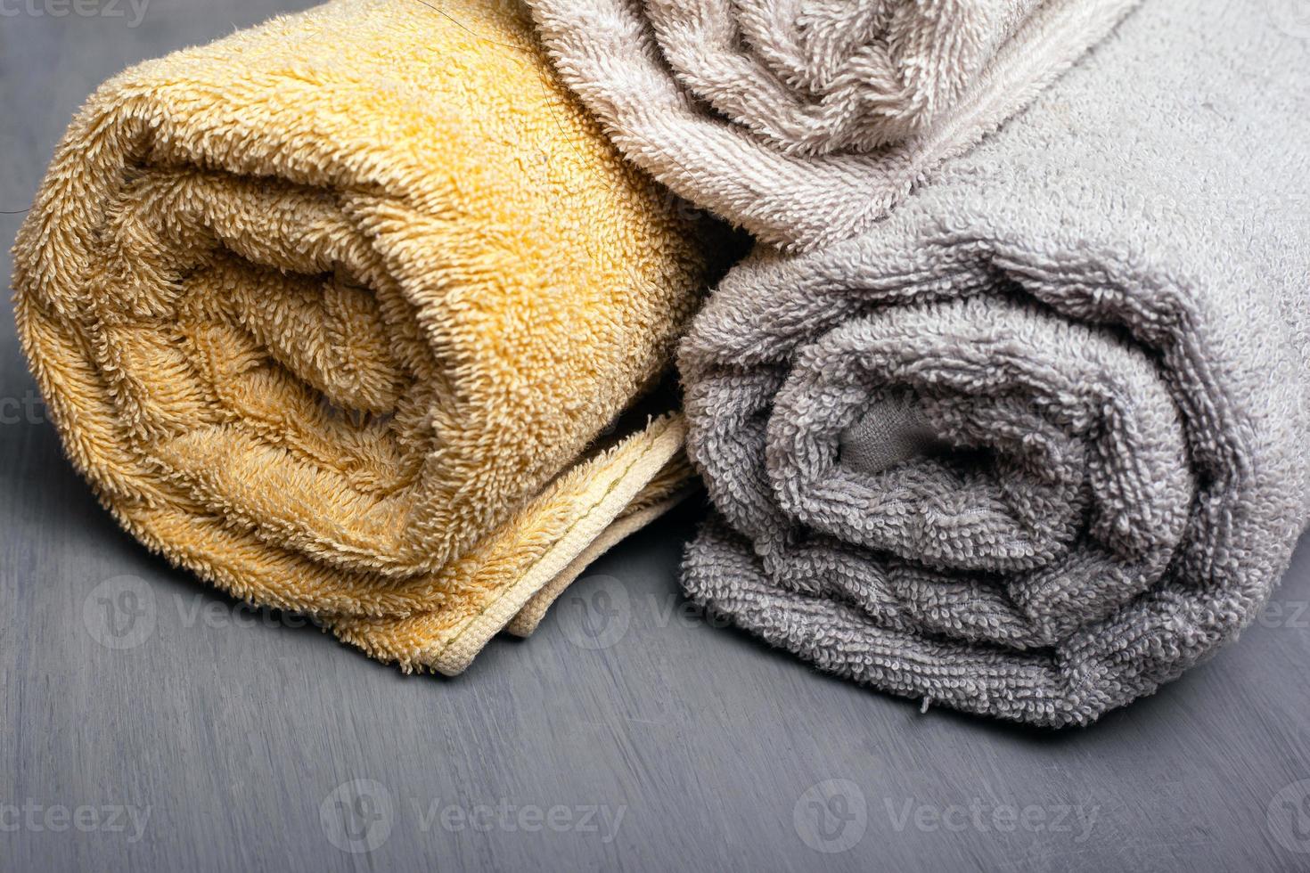 Multi-colored bath towels on a gray background photo