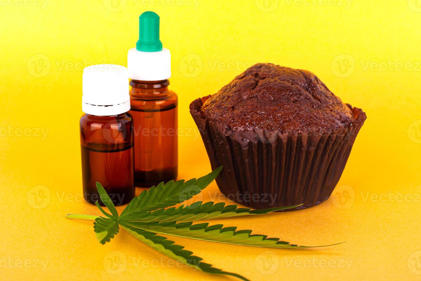 Chocolate cake with cannabis oil on yellow background photo