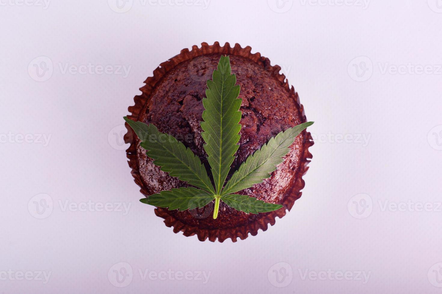 muffin de chocolate y hoja de marihuana verde foto