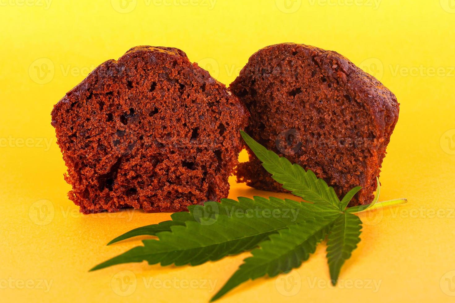 Chocolate muffin cake with marijuana on yellow background photo