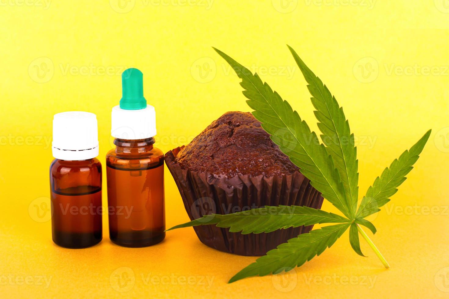 Chocolate cake with cannabis oil on yellow background photo