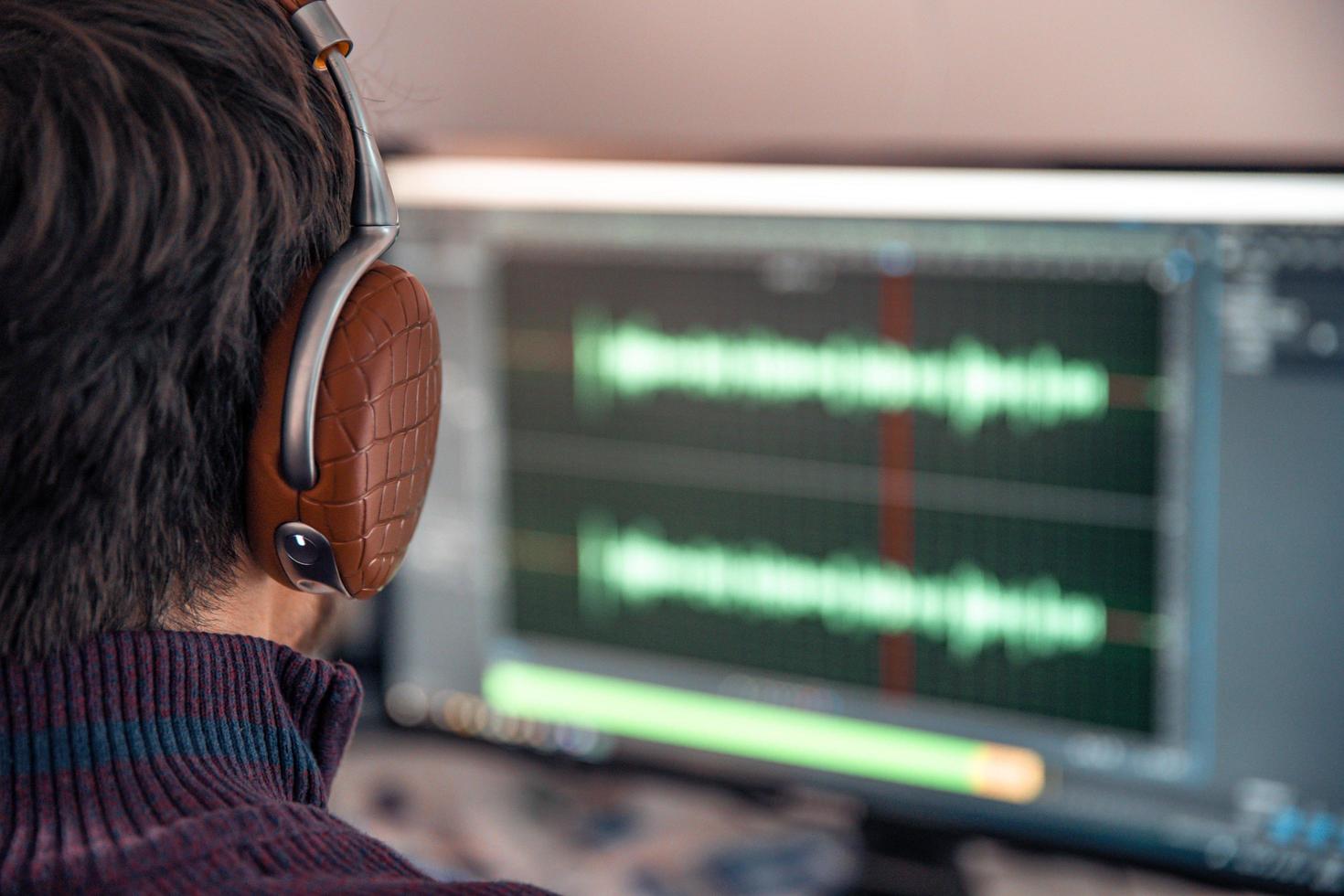 hombre en el estudio graba y modifica el canto, la voz y la música para uso comercial foto