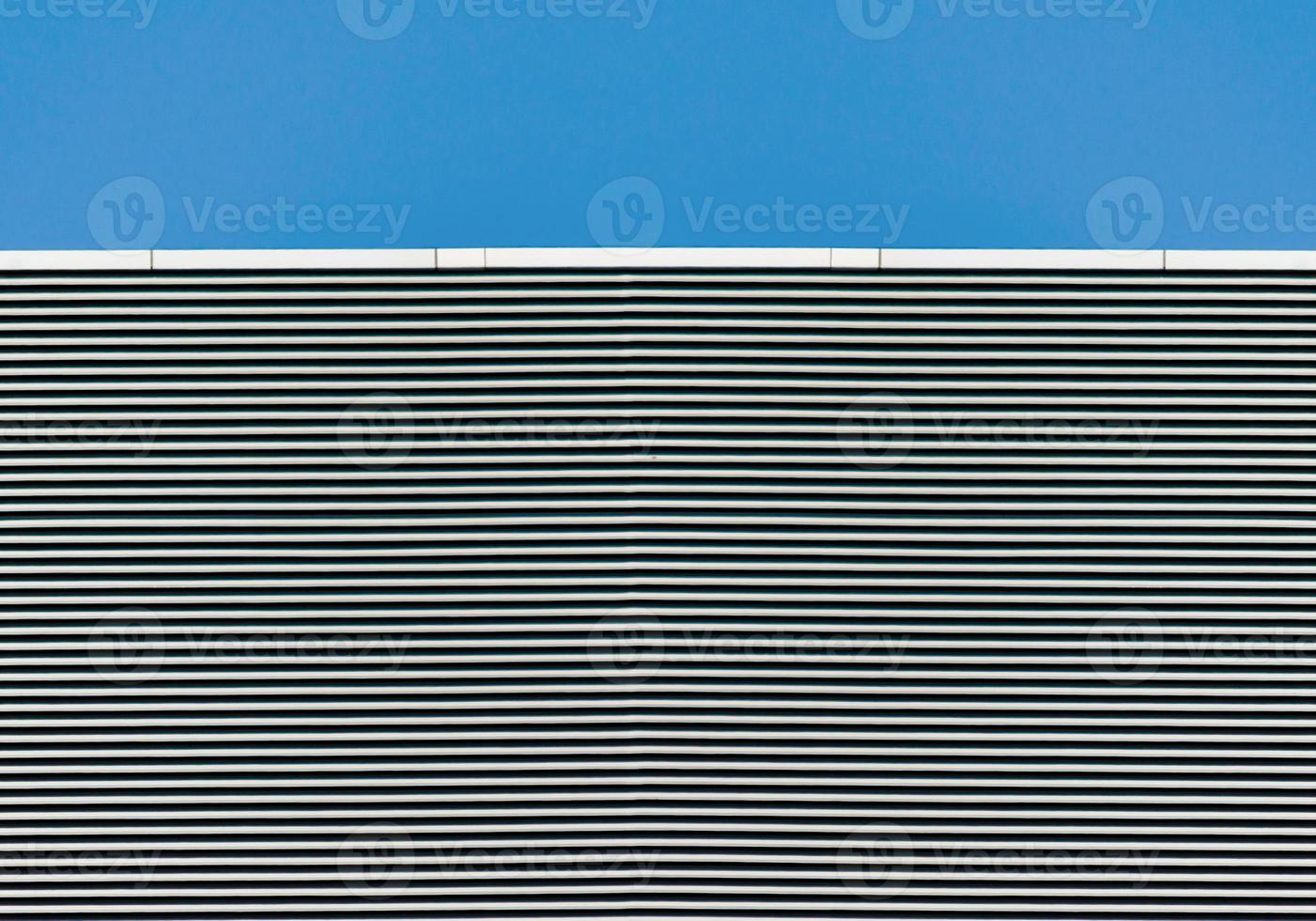 Striped wall with blue clear sky photo