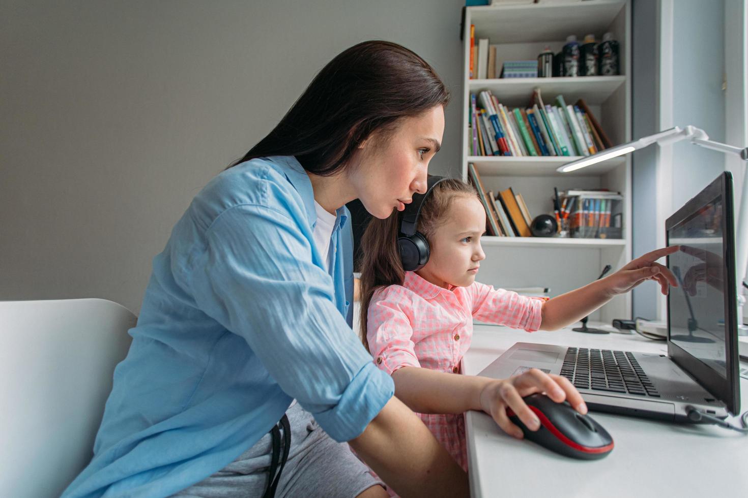 Mother helping child with virtual school photo