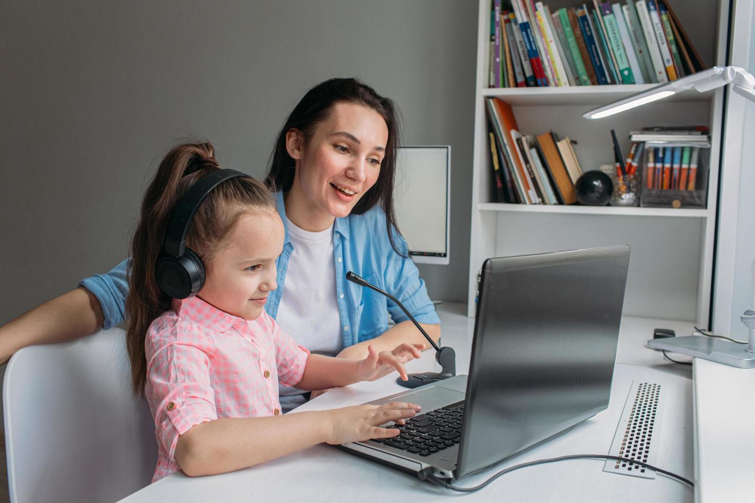 madre ayudando a su hija con la escuela en casa foto