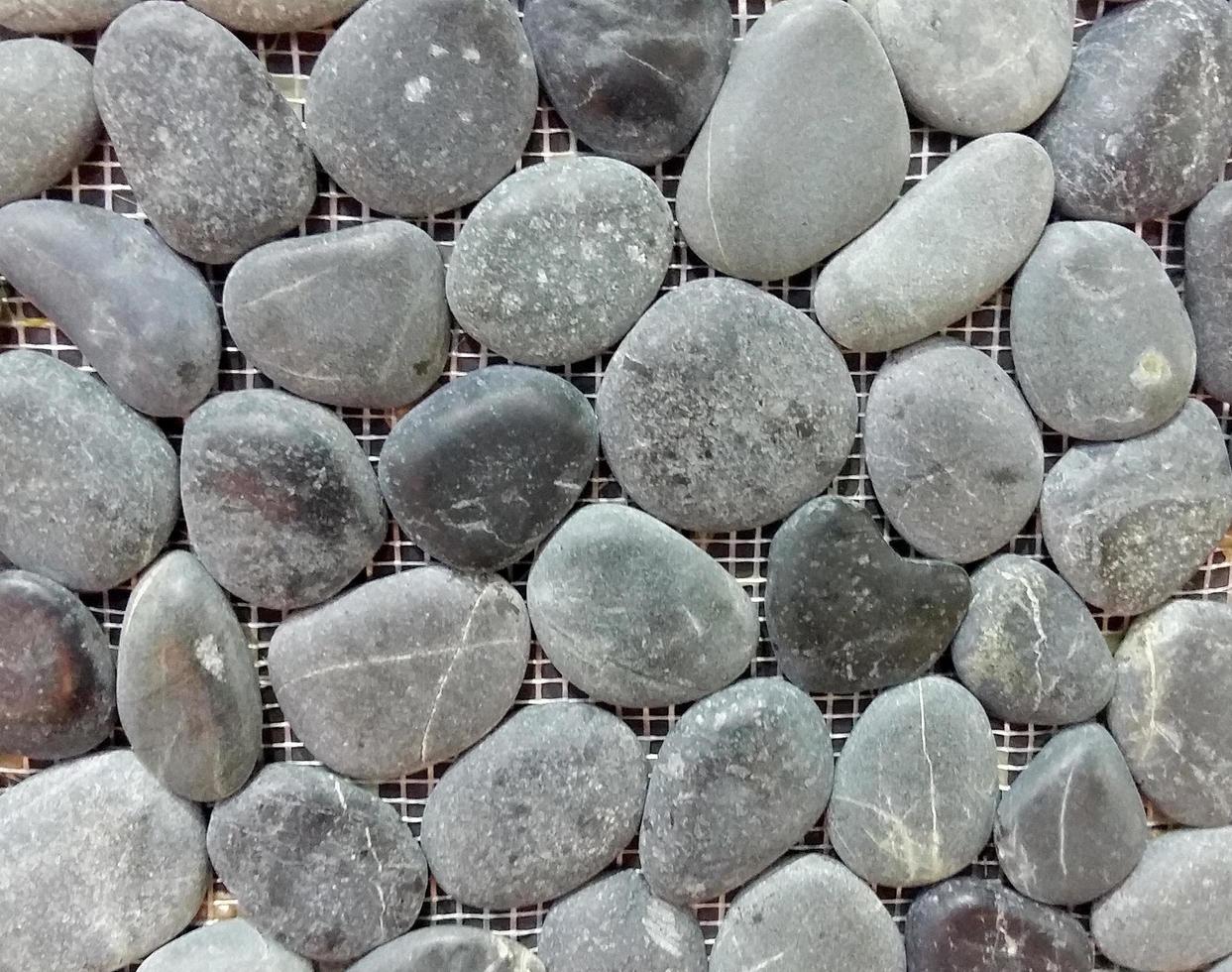 Fondo de textura de pared de piedra de guijarro de mar gris foto