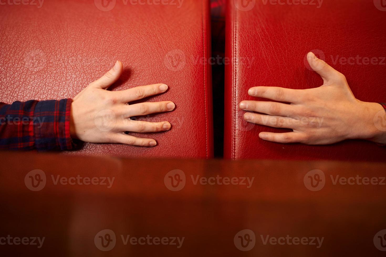 manos masculinas y femeninas se están alcanzando sobre un fondo rojo. concepto de cuidado, apoyo y amor. foto