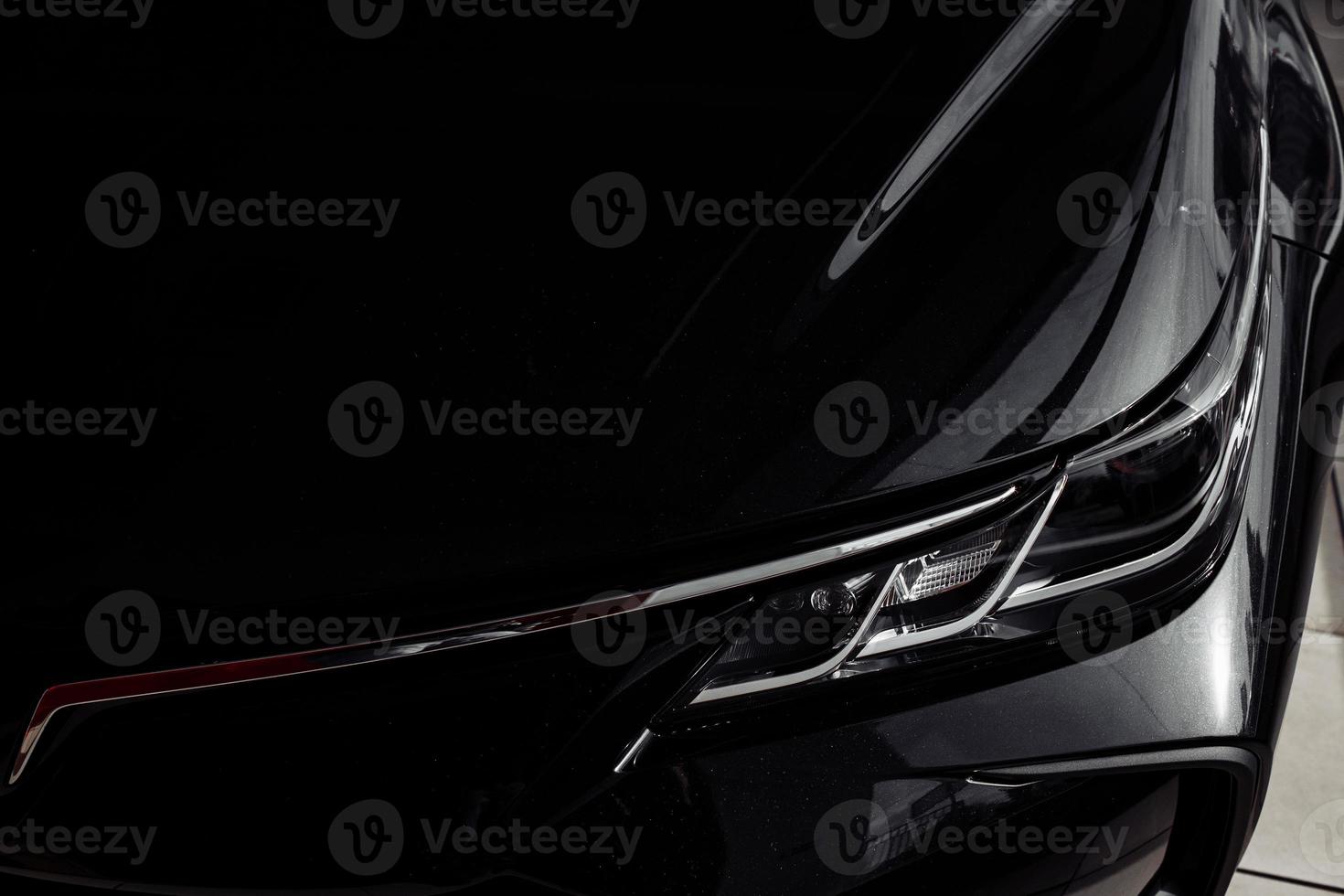 Headlight of modern prestigious black car close up photo