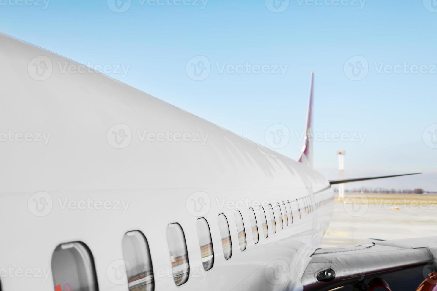 avión ojo de buey ventana lateral avión. Avión de motor a reacción de pasajeros pesado blanco en la pista de aterrizaje en el aeropuerto contra el cielo azul, el transporte de la aviación de fondo del tema foto