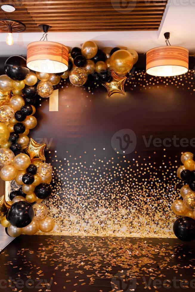 Golden and black balloons decorated with black and yellow balloons. Stylish party with balloons. Place of celebration. photo