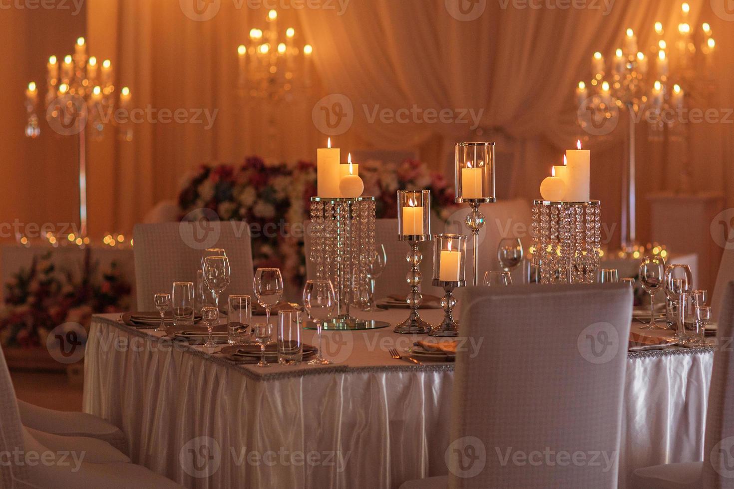 Wedding hall decoration with crystal chandeliers and candles photo