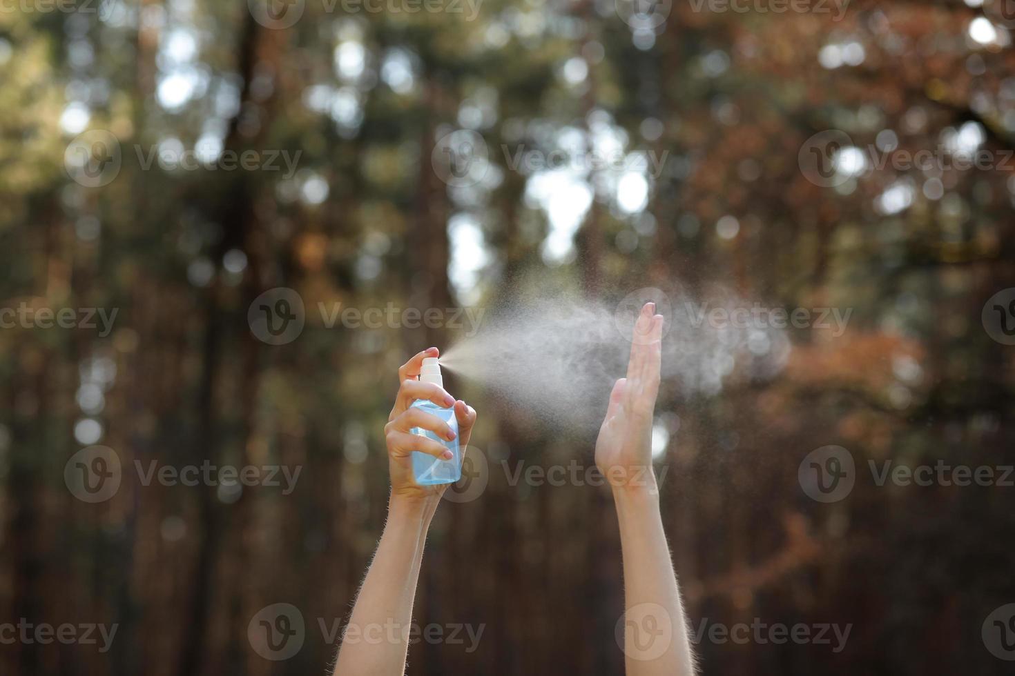 manos de las mujeres aplicando spray de alcohol o spray antibacteriano al aire libre para evitar la propagación de gérmenes, bacterias y virus, tiempo de cuarentena, concéntrese en las manos cercanas. coronavirus. Copie el espacio. foto