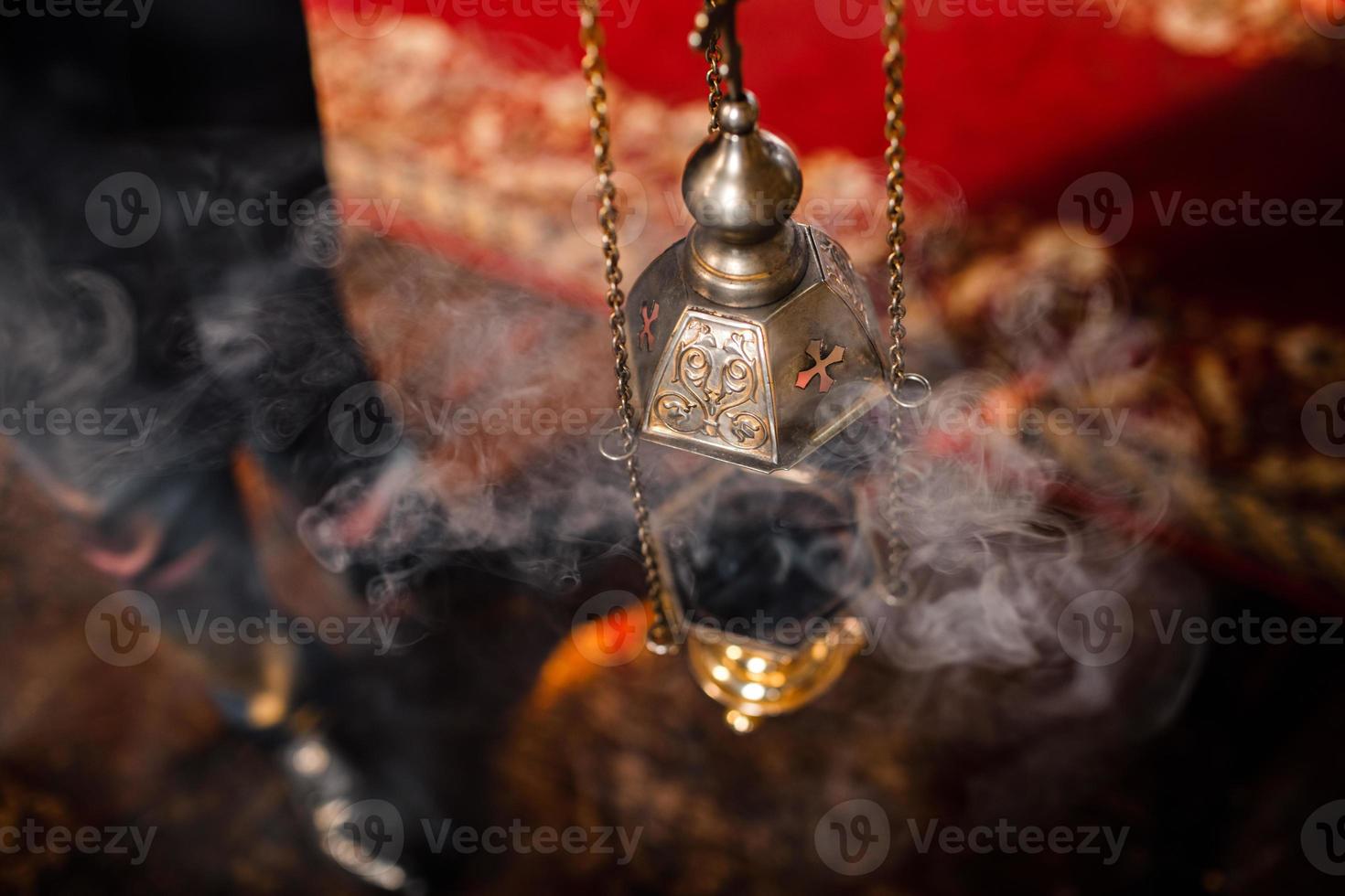 A priest's censer hangs on an old wall in the Orthodox Church. Copper incense with burning coal inside. Service in the concept of the Orthodox Church. Adoration. photo