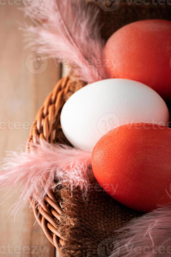 Huevos de pascua de color blanco y naranja sobre un fondo de madera clara foto