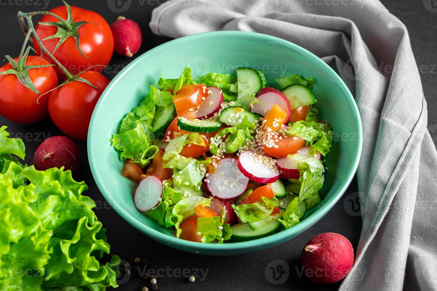 Fresh vegetable salad in a ceramic bowl on gray background photo