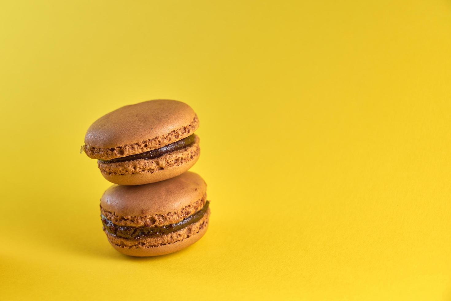 Cake macaron close up on a yellow background, flavor almond cookies pastel colors, and space for text. photo