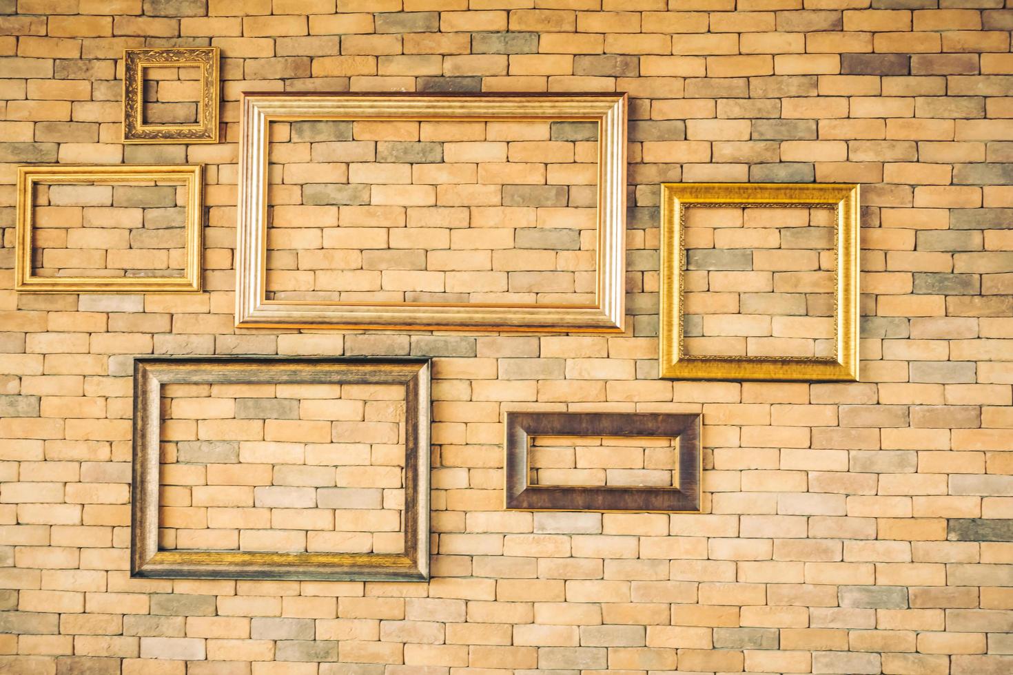 Blank photo frames on brick wall