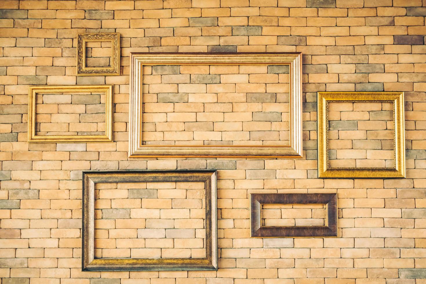 Blank photo frames on brick wall