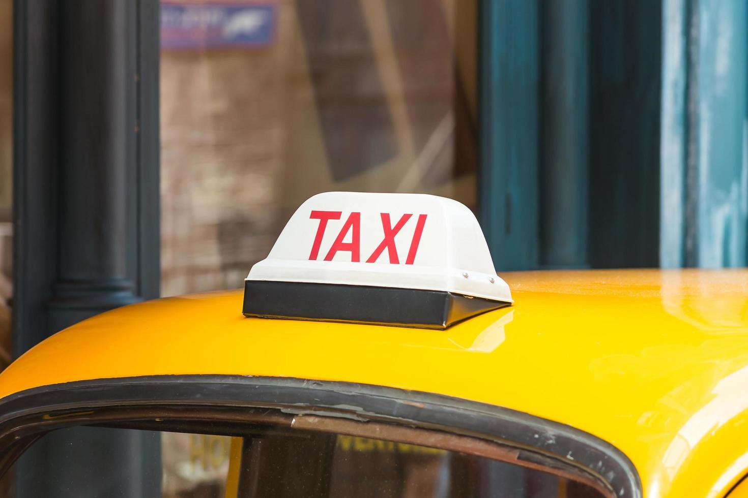 Taxi sign on on the roof of a car photo